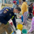 Bombero ayudando a la comunidad llenado baldes de agua