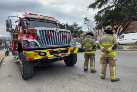 Bomberos parados al frente del camión de bomberos